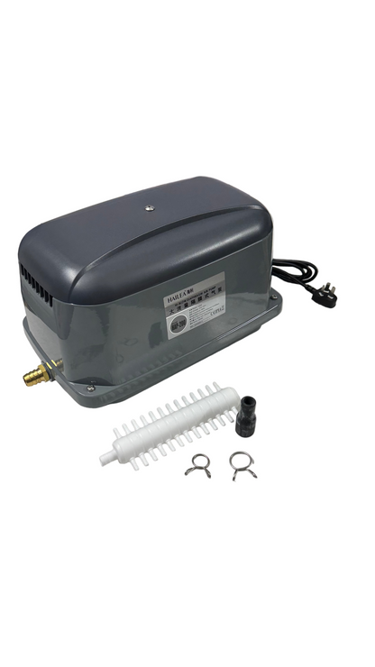 Gray air compressor with accessories on a white surface